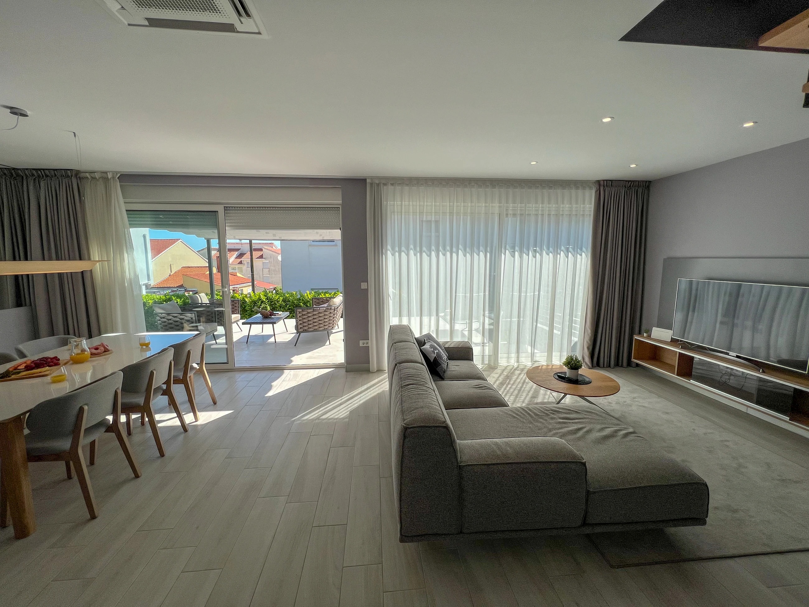 Bright living room with terrace access at Three-Bedroom Premium Apartment Near the Sea