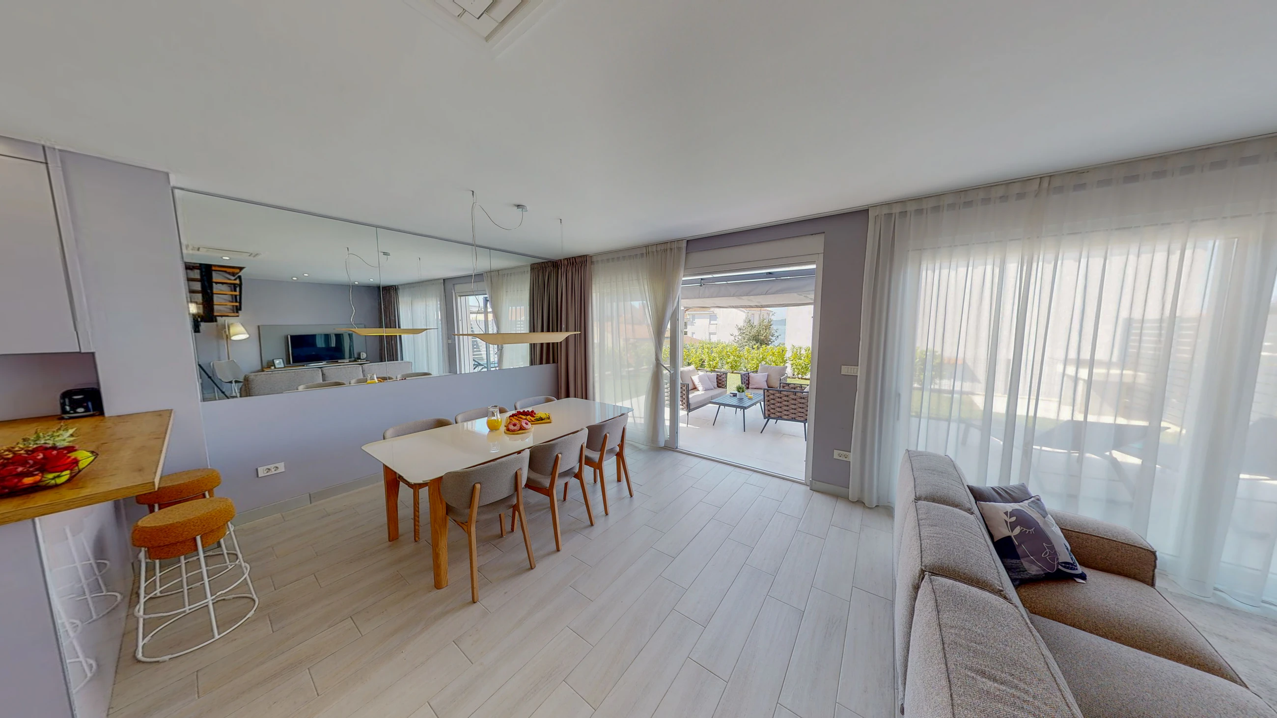 Dining and living area opening outdoors at Three-Bedroom Premium Apartment Near the Sea