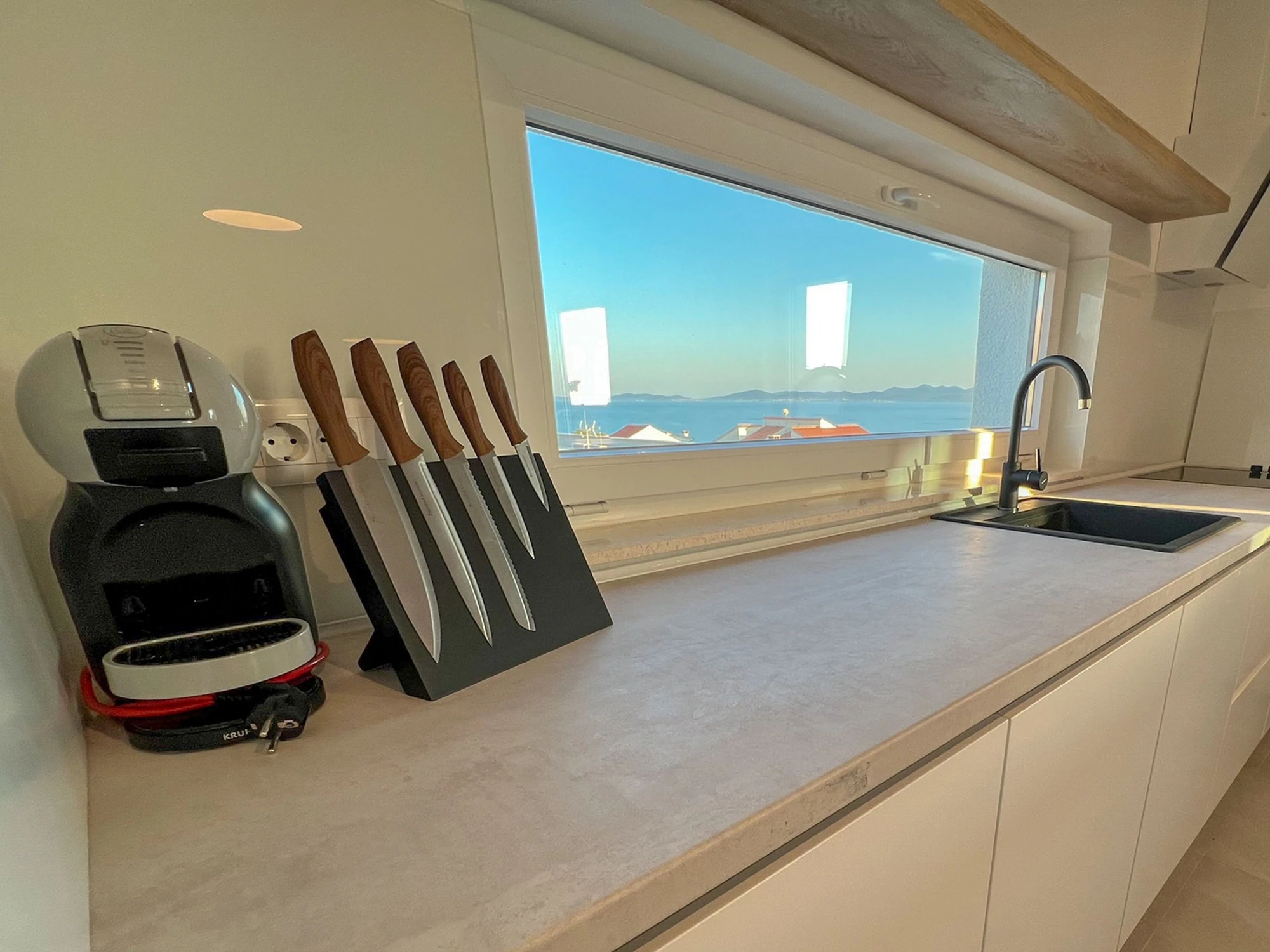 Kitchen window framing the sea at Three-Bedroom Apartment Near the Sea