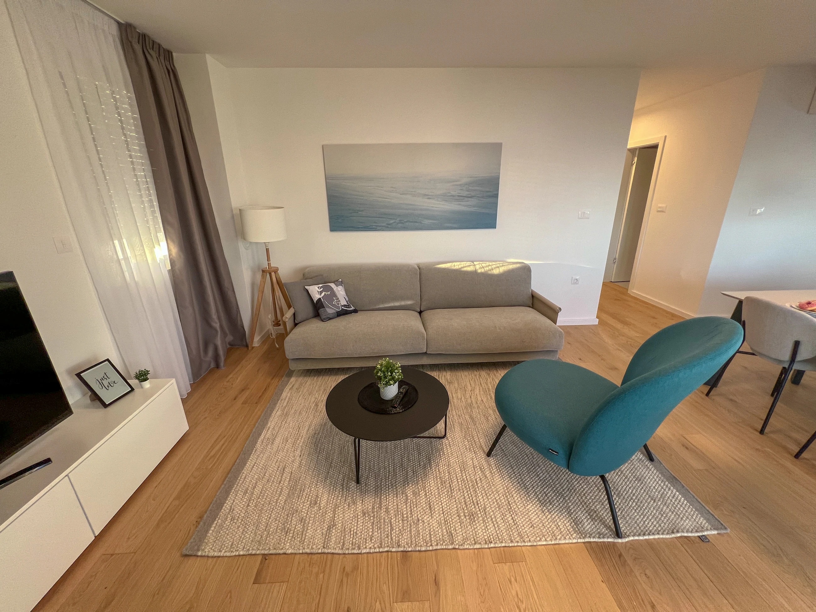 Living room in calm coastal tones at Three-Bedroom Apartment Near the Sea