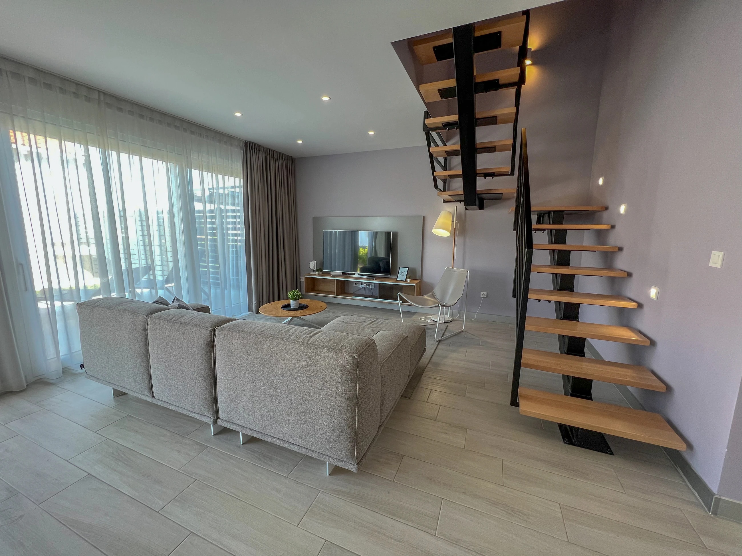 Living room and open staircase at Three-Bedroom Apartment with Private Pool Near the Sea