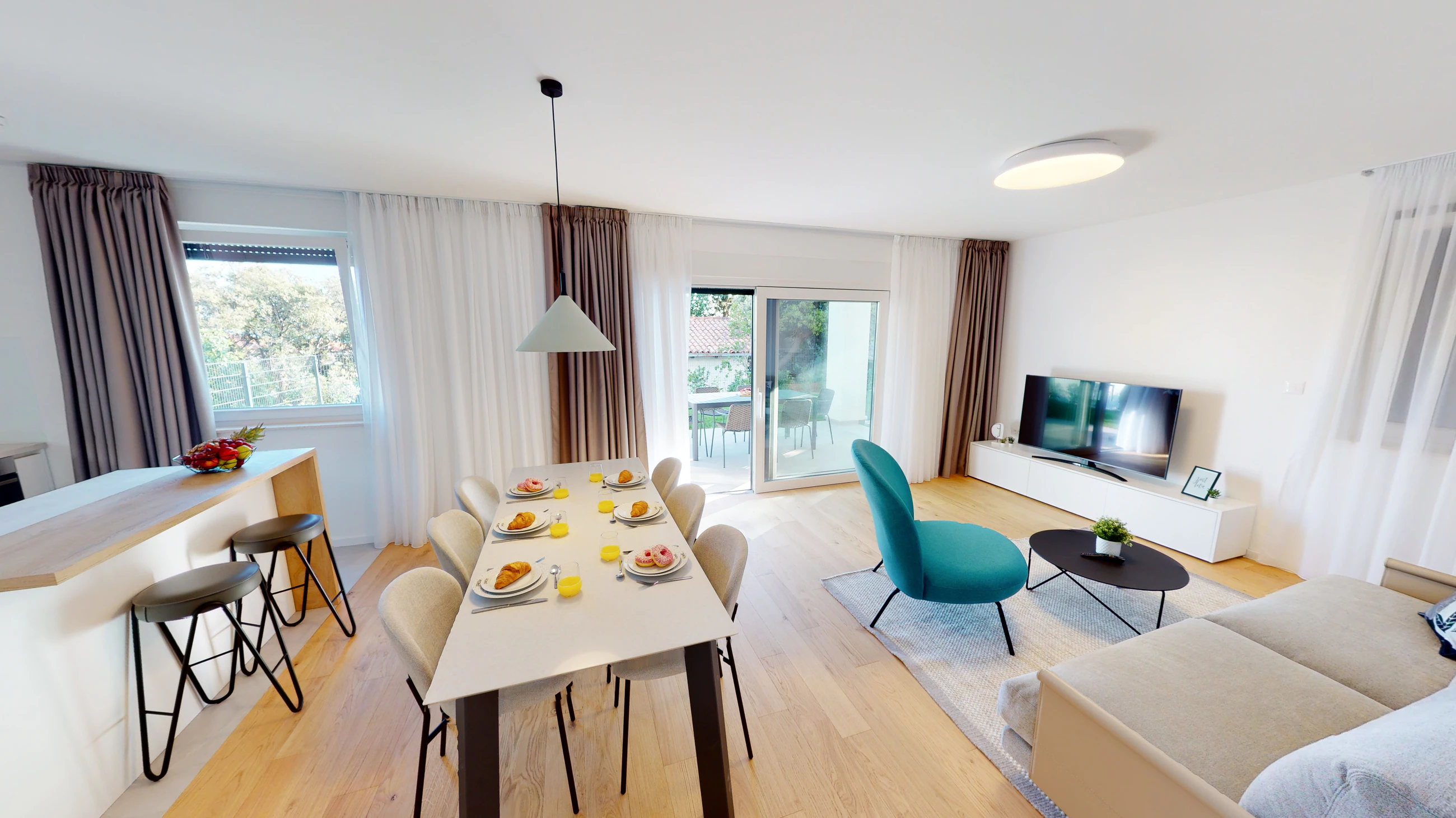 Bright living room beside the dining area at Three-Bedroom Apartment with Private Pool Near the Sea