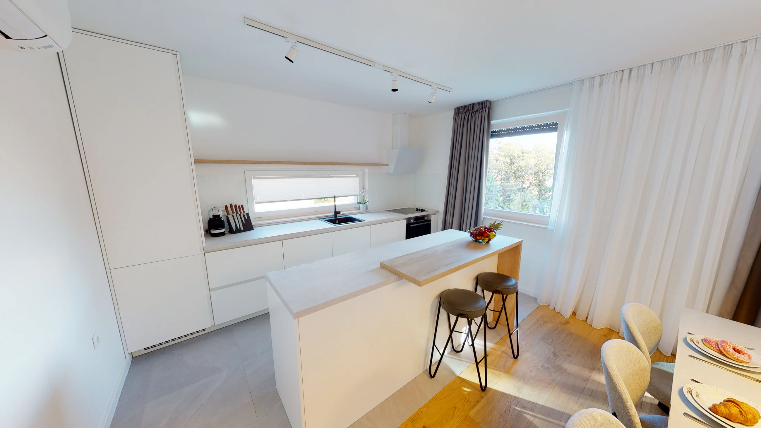 White kitchen with a breakfast bar at Three-Bedroom Apartment with Private Pool Near the Sea