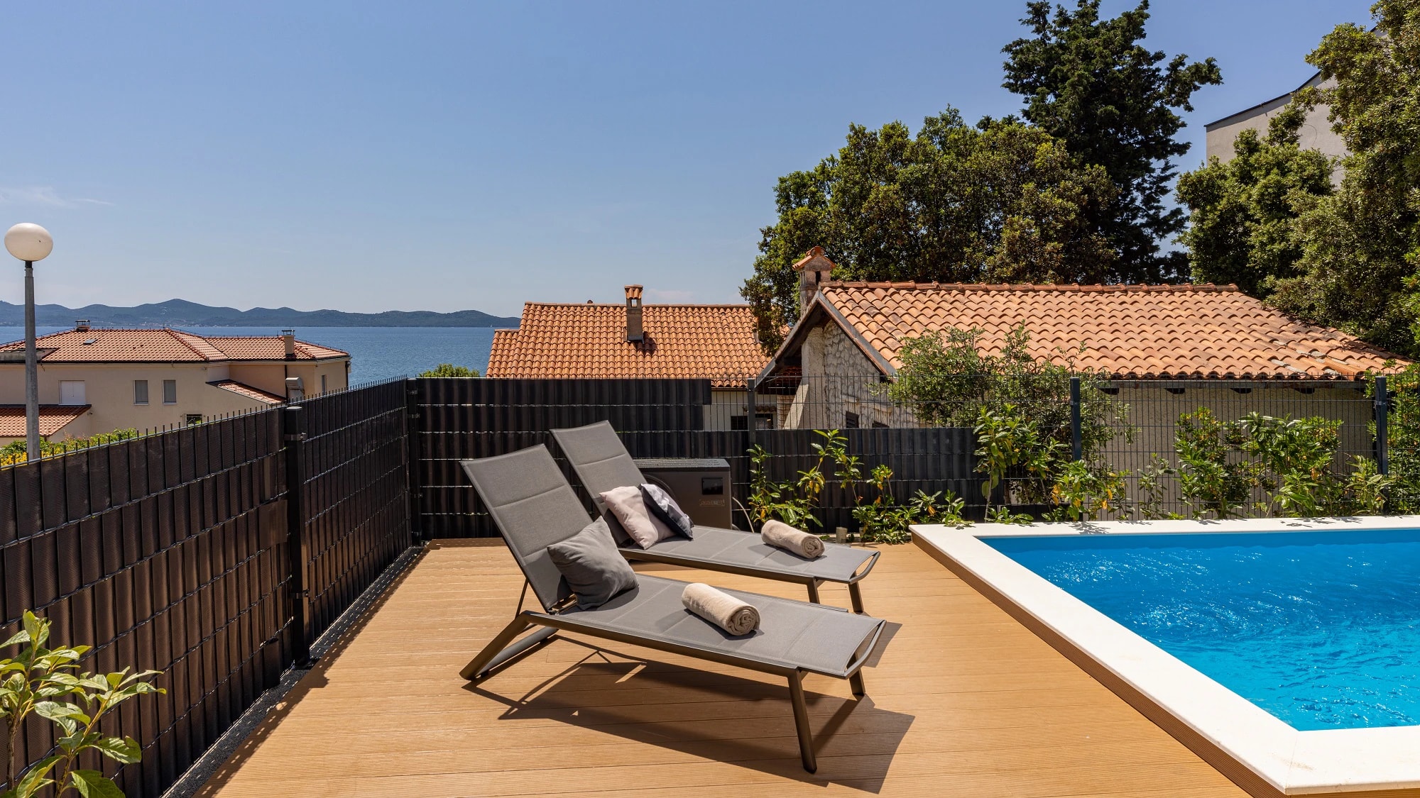 Sun loungers beside the private pool at Three-Bedroom Apartment with Private Pool Near the Sea