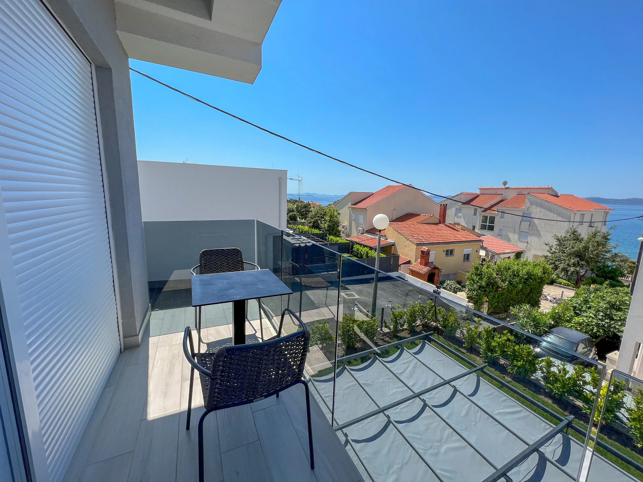 Furnished balcony overlooking Kožino at Three-Bedroom Apartment with Private Pool Near the Sea