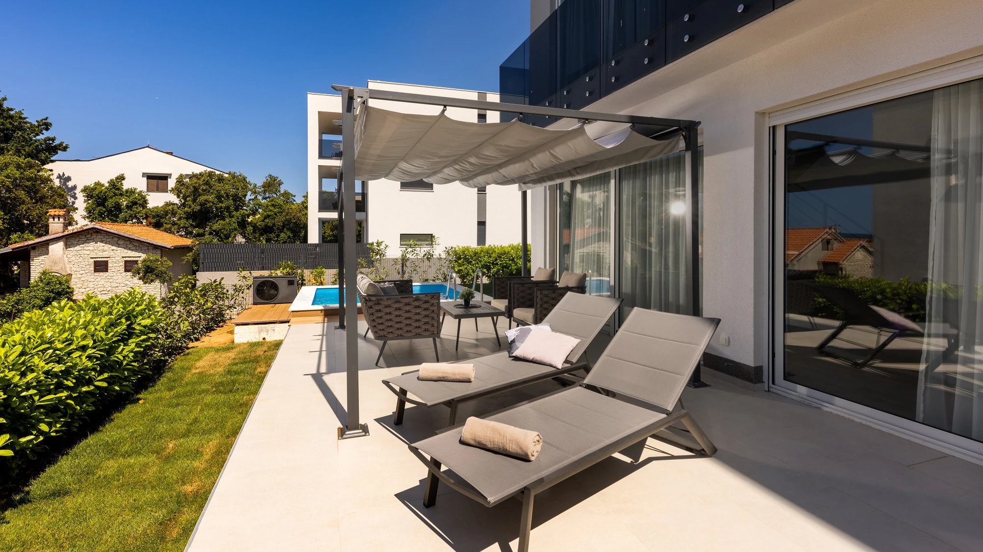 Sun loungers on the private pool terrace at Three-Bedroom Apartment with Private Pool Near the Sea