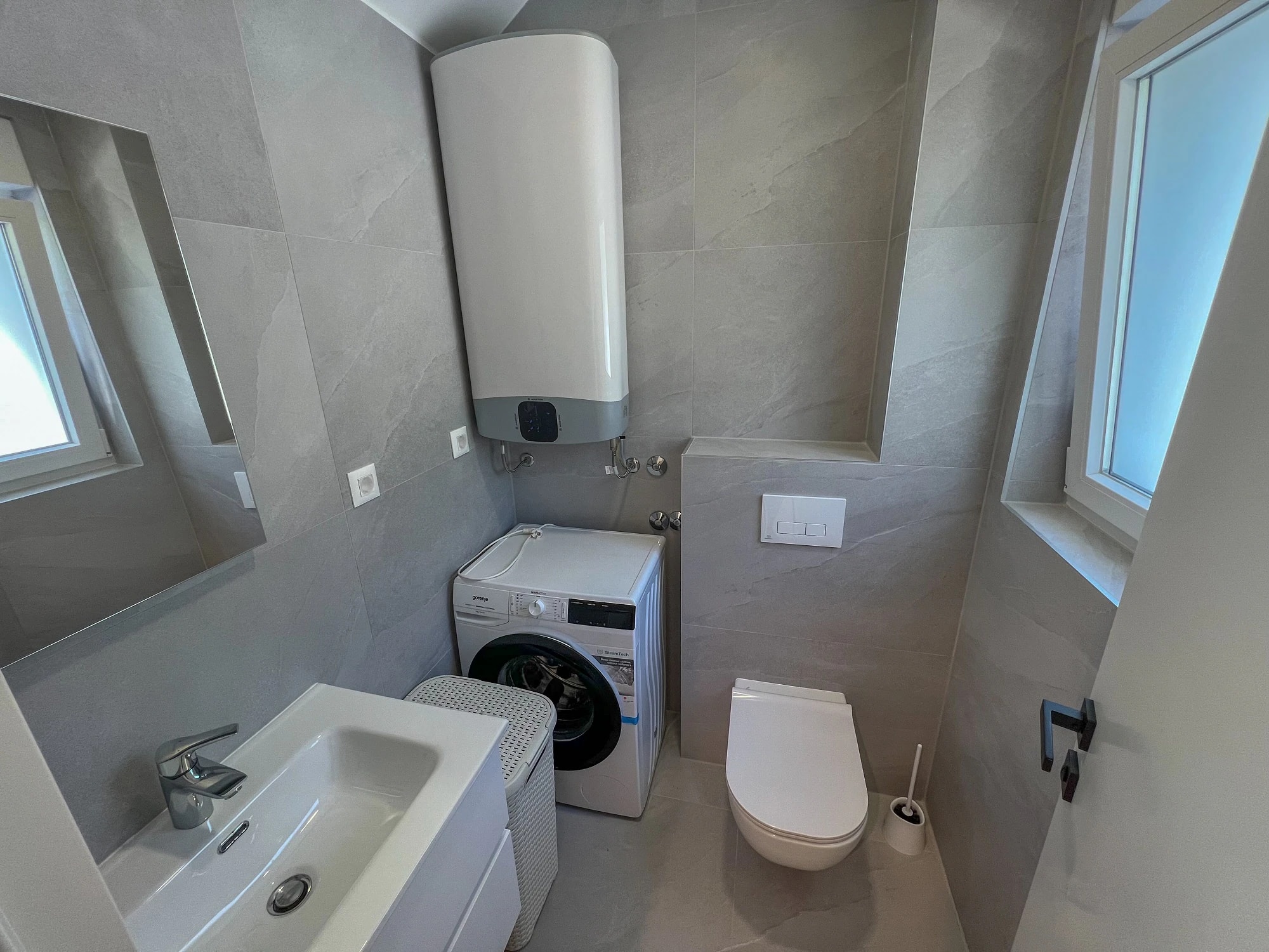 Utility bathroom with washing machine at Three-Bedroom Apartment with Private Pool Near the Sea