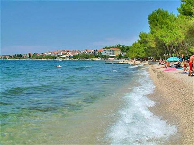 Pebble waterfront and clear water at Diklo